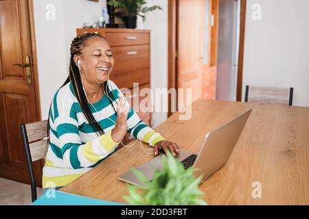 Donna anziana africana che fa videochiamata durante il blocco del coronavirus - La vecchia persona che si diverte con le tendenze tecnologiche - distanza sociale Concetto - Focus on Foto Stock