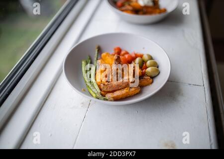 Patatine dolci fritte con formaggio di cottage e più verdure su una piastra Foto Stock