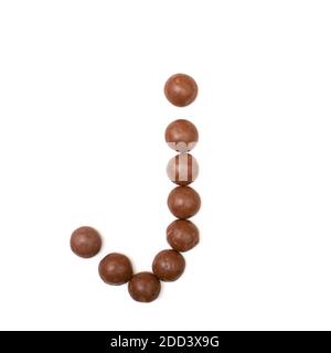 La lettera "J" scritta in cioccolato marrone Pepernoten, una caramella tradizionale olandese per la festa Sinterklaas il 5 dicembre Foto Stock