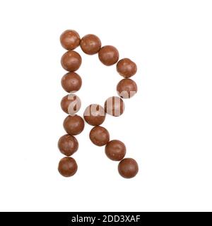 La lettera "R" scritta in cioccolato marrone Pepernoten, una tradizionale caramella olandese per la festa Sinterklaas il 5 dicembre Foto Stock