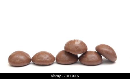 Vista laterale della tradizionale Pipernoten olandese di cioccolato Candy Brown Uno sfondo bianco per il Sinterklaas Party il 5 dicembre Foto Stock