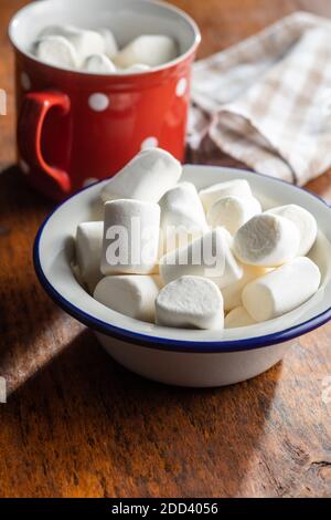 Caramelle dolci bianche in ciotola su un tavolo di legno. Foto Stock