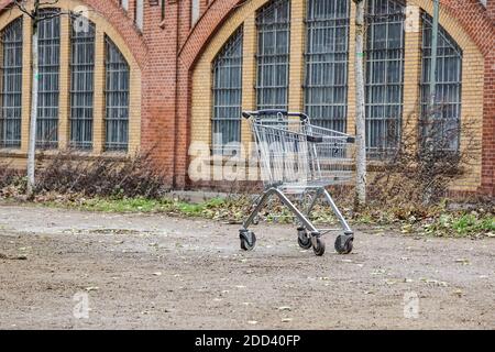 carrello vuoto . crisi commerciale, carrello abbandonato in un'area industriale deserta e vuota. Simbolo della periferia di città abbandonate Foto Stock