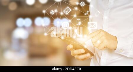 CONTATTACI. Mano di uomo d'affari che usa lo smartphone mobile con l'icona (telefono, posta, indirizzo). Foto Stock