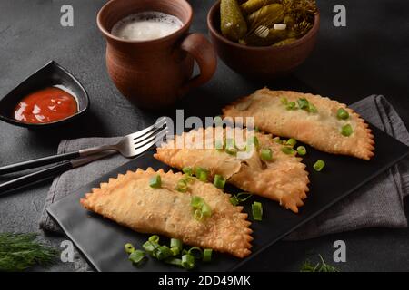 Cheburek con carne e cipolla primaverile Foto Stock