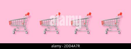 Concetto di amante dello shopping. Carrello con motivo senza cuciture su sfondo rosa. Composizione piatta, vista dall'alto Foto Stock