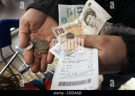 GRAN BRETAGNA / Inghilterra / sterline banconote e monete in Hand.man umano contando monete e banconote per risparmiare. Risparmio di denaro Foto Stock