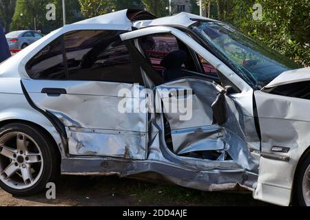 Auto d'argento dopo un terribile incidente d'urto. Impatto frontale e laterale. Foto di concetto di velocità. Assicurazione sulla vita. Incidente oltre il recupero. Vista laterale. Foto Stock