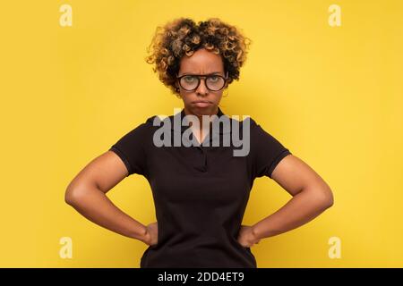 Giovane donna afroamericana con gli occhiali depressi e la preoccupazione per la sofferenza. Triste espressione facciale negativa. Foto Stock