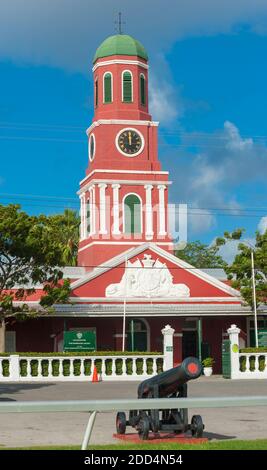 Famosa torre dell'orologio rosso sulla casa di guardia principale della Garrison Savannah con vecchi cannoni di fronte. Unesco guarnigione zona storica Bridgetown, Barb Foto Stock