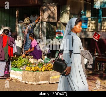 Una suora cammina su un mercato stradale sulla Shillong-Guwahati autostrada, Meghalaya, India. Foto Stock