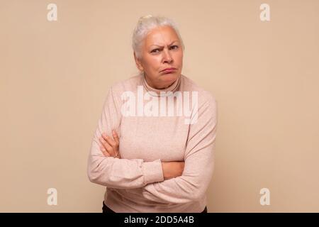 Arrabbiato donna ispanica anziana con le braccia incrociate che vi ascoltano con attenzione. Foto Stock