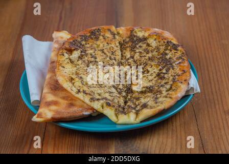 Manakish | Libanese tradizionale prima colazione Pasticceria in piatto su naturale tavolo in legno Foto Stock