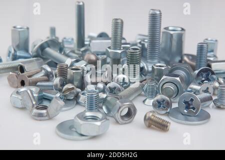 Chromeplated bulloni e dadi su sfondo bianco Foto Stock