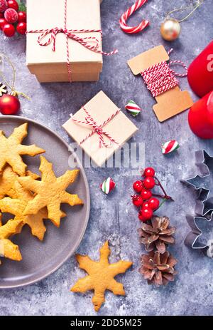 Decorazione di Natale con coni, biscotti, scatole regalo, candele rosse, caramelle vista dall'alto Foto Stock