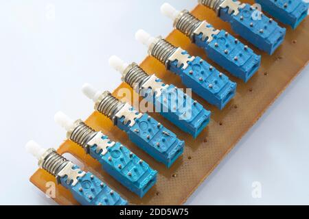 Set di vecchi interruttori elettrici e pulsanti isolati su sfondo bianco. Pressione meccanica blu con molla su circuito stampato Foto Stock