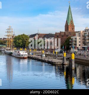 Navi Waterside e appartamenti intelligenti - sulle rive del fiume Weser a Brema, il campanile è la Chiesa di San Martino. Foto Stock