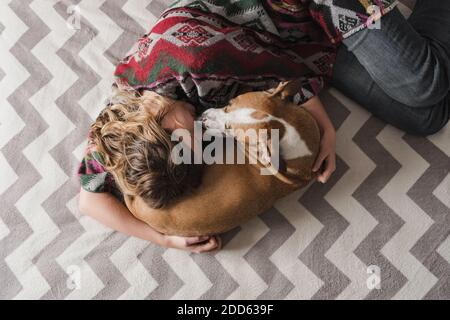 Donna si distende con un cane e la abbraccia. Supporto emotivo, depressione e stress con animali domestici durante il blocco e rimanere a casa ordini Foto Stock