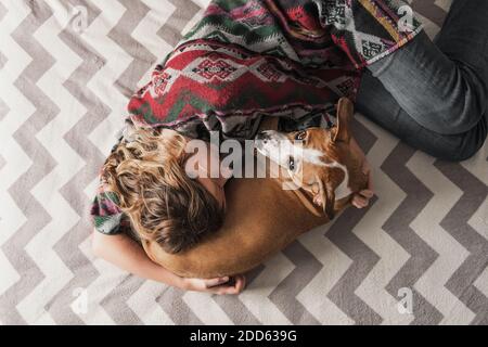 Donna si distende con un cane e la abbraccia. Supporto emotivo, depressione e stress con animali domestici durante il blocco e rimanere a casa ordini Foto Stock