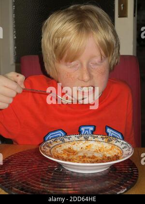 Ragazzo che mangia gli spaghetti bolognesi Foto Stock