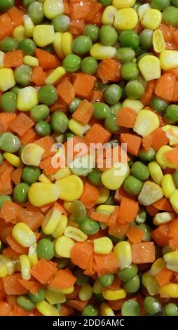 Consistenza di piselli, carote e cornetti a dadini colorati. Foto Stock