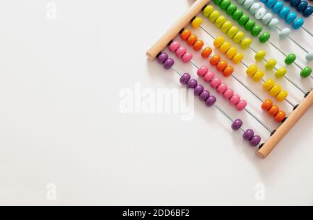 Scuola abacus con perle colorate su sfondo bianco, vista ravvicinata, spazio copia. Conteggio di apprendimento dei bambini, concetto di classe matematica dei bambini Foto Stock