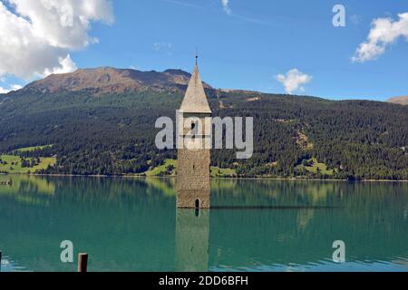 La vecchia torre della chiesa di Graun sul lago Reschen in Val Venosta Foto Stock