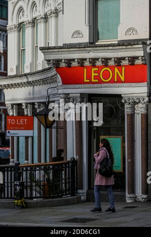 Londra, Regno Unito. 24 Nov 2020. Un ristorante leon di proprietà per lasciare come si lotta con il blocco nella città accanto a greggs, uno dei relativi successi di blocco. La gente è ancora fuori nel centro di londra, nonostante il nuovo blocco che è ora in vigore. Le luci di Natale sono accese ma i negozi sono chiusi. Molte persone indossano maschere, anche all'esterno. Credit: Guy Bell/Alamy Live News Foto Stock