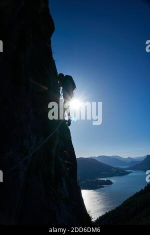 Una persona nella via ferrata di Drachenwand con il Mondsee sullo sfondo Foto Stock