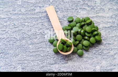 Pillole verdi di clorella e spirulina. Bevanda a fuoco selettivo Foto Stock