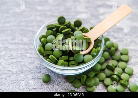 Pillole verdi di clorella e spirulina. Bevanda a fuoco selettivo Foto Stock