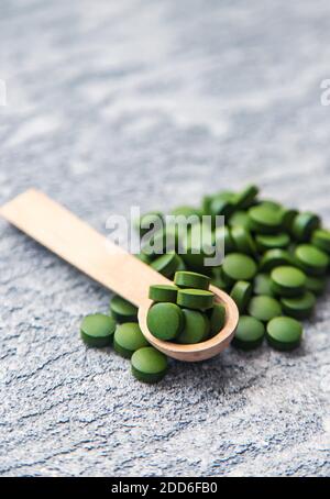 Pillole verdi di clorella e spirulina. Bevanda a fuoco selettivo Foto Stock