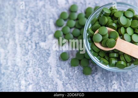 Pillole verdi di clorella e spirulina. Bevanda a fuoco selettivo Foto Stock