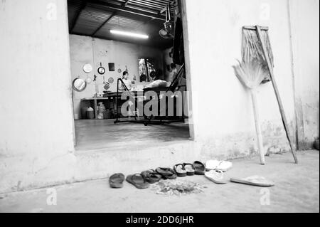 Foto in bianco e nero delle scarpe sinistra fuori della cucina in una famiglia nel delta del Mekong, Vietnam, Sud-est asiatico Foto Stock