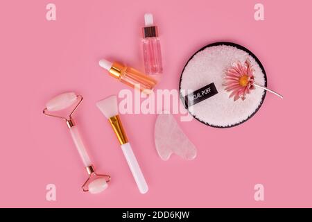 Rullo per il viso Jade e pietra Gua sha per il massaggio del viso. Strumenti anti-invecchiamento per la cura della pelle, flacone per siero viso, rullo massaggiante. Naturale organico essenziale Foto Stock