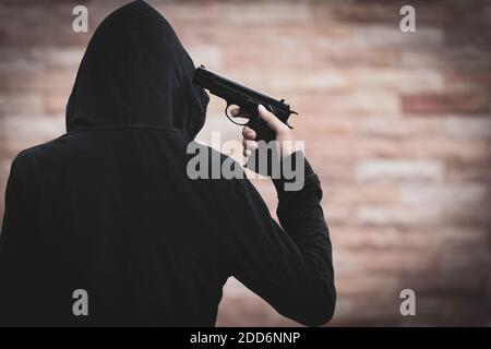 Un uomo si suicidò con una pistola per uccidersi. Giovane uomo che punta una pistola alla testa. Concetto di suicidio. Foto Stock