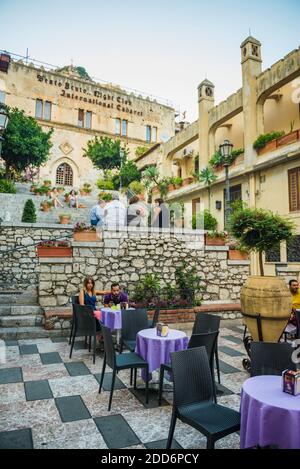 Taormina, turisti in un caffè di Palazzo Ciampoli su corso Umberto, la strada principale nel centro di Taormina, Sicilia, Italia, Europa Foto Stock