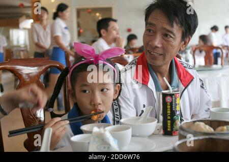 NO FILM, NO VIDEO, NO TV, NO DOCUMENTARIO - Zhang Huimin, 8, a sinistra, mangia la colazione con suo padre, Zhang Jianmin il 24 marzo 2007 nella città meridionale di Lingao, Cina, dopo aver finito la sua corsa pre-alba. È la più giovane maratoneta della Cina. È troppo giovane per le Olimpiadi del 2008 a Pechino, ma è stata presentata in una recente promozione olimpica sulla televisione statale cinese. Foto di Evan Osnos/Chicago Tribune/MCT/Cameleon/ABACAPRESS.COM Foto Stock