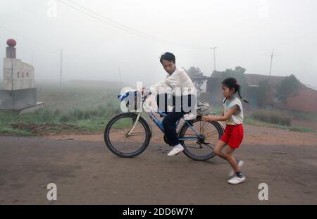 NO FILM, NO VIDEO, NO TV, NO DOCUMENTARIO - Zhang Huimin, 8, a destra, corre all'alba con suo padre, Zhang Jianmin il 24 marzo 2007 nella città meridionale di Lingao, Cina. È la più giovane maratoneta della Cina. È troppo giovane per le Olimpiadi del 2008 a Pechino, ma è stata presentata in una recente promozione olimpica sulla televisione statale cinese. Foto di Evan Osnos/Chicago Tribune/MCT/Cameleon/ABACAPRESS.COM Foto Stock