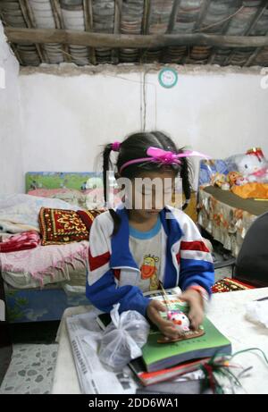 NO FILM, NO VIDEO, NO TV, NO DOCUMENTARIO - Zhang Huimin, 8, gioca con un giocattolo a circa 2:45 prima della sua corsa pre-alba il 24 marzo 2007 nella città meridionale di Lingao, Cina. È la più giovane maratoneta della Cina. È troppo giovane per le Olimpiadi del 2008 a Pechino, ma è stata presentata in una recente promozione olimpica sulla televisione statale cinese. Foto di Evan Osnos/Chicago Tribune/MCT/Cameleon/ABACAPRESS.COM Foto Stock