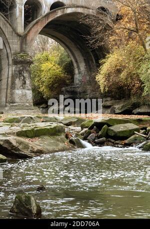 Un fiume con un ponte ferroviario secolare che tiene la scena. Foto Stock