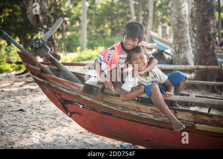 I bambini giocano su una tradizionale barca da pesca al villaggio di pescatori di Sungai Pinang, vicino a Padang, a Sumatra Ovest, Indonesia, Asia Foto Stock