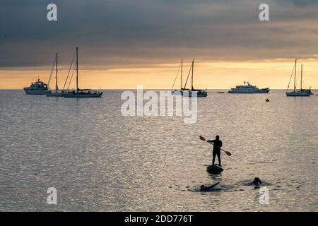 Paddle boarding durante il tramonto sulla spiaggia di Puerto Barquerizo Moreno Foto Stock