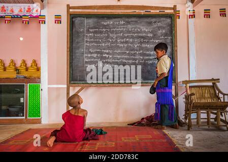 Monaco che insegna giovani monaci novizi in un tempio buddista a Pindaya, Stato Shan, Myanmar (Birmania) Foto Stock