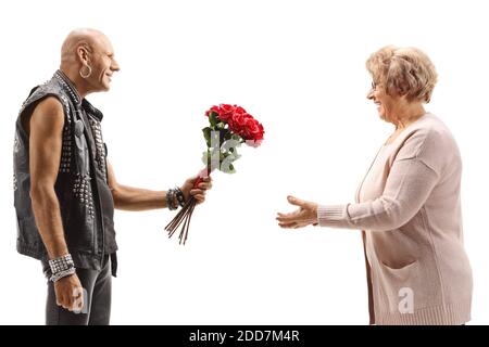 Punk calvo che dà un bouquet di rose ad un anziano donna isolata su sfondo bianco Foto Stock