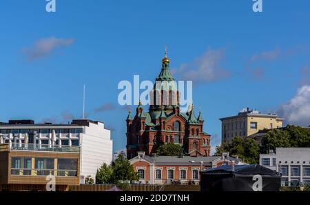 Cattedrale di Uspenski in mattoni rossi con cupole verdi e croci dorate contro il cielo blu Foto Stock