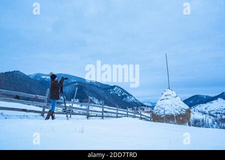 Fotografo che fotografa i paesaggi invernali dei Carpazi nei pressi di Bran, Transilvania, Romania Foto Stock