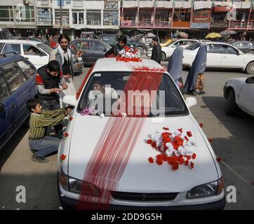 NESSUN FILM, NESSUN VIDEO, NESSUNA TV, NESSUN DOCUMENTARIO - UN gruppo di giovani uomini decorano l'auto della sposa e dello sposo in preparazione ad una cerimonia nuziale a Kabul, Afghanistan, 9 novembre 2009. Foto di Chuck Liddy/Raleigh News & Observer/MCT/ABACAPRESS.COM Foto Stock