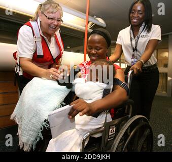 NO FILM, NO VIDEO, NO TV, NO DOCUMENTARIO - l'operatrice della Croce Rossa americana Linda Sperberg, a sinistra, fornisce un caloroso benvenuto ad una famiglia haitiana quando arrivano alla stazione della Croce Rossa all'Aeroporto Internazionale di Orlando, Florida, Lunedi, 18 Gennaio 2010. Gli evacuati haitiani sono stati trasportati a OIA in autobus dopo aver volato all'aeroporto di Sanford-Orlando. Foto di Joe Burbank/Orlando Sentinel/MCT/ABACAPRESS.COM Foto Stock