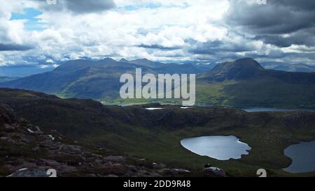 Vista a sud dalle pendici di Bein Ghobhlach, fino a un Teallach e Sail Mhor e le colline dei campi di pescatori. Macchie di sole sulle colline. Include parte Foto Stock